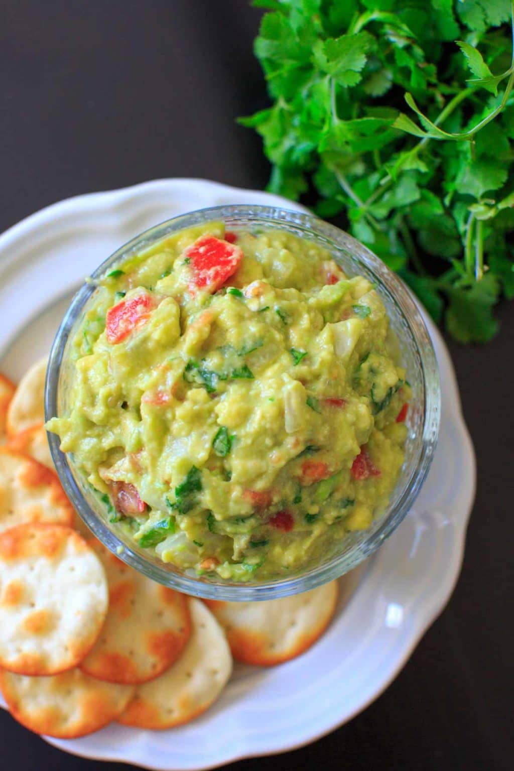 best ever guacamole in dish on top of white plate with crackers