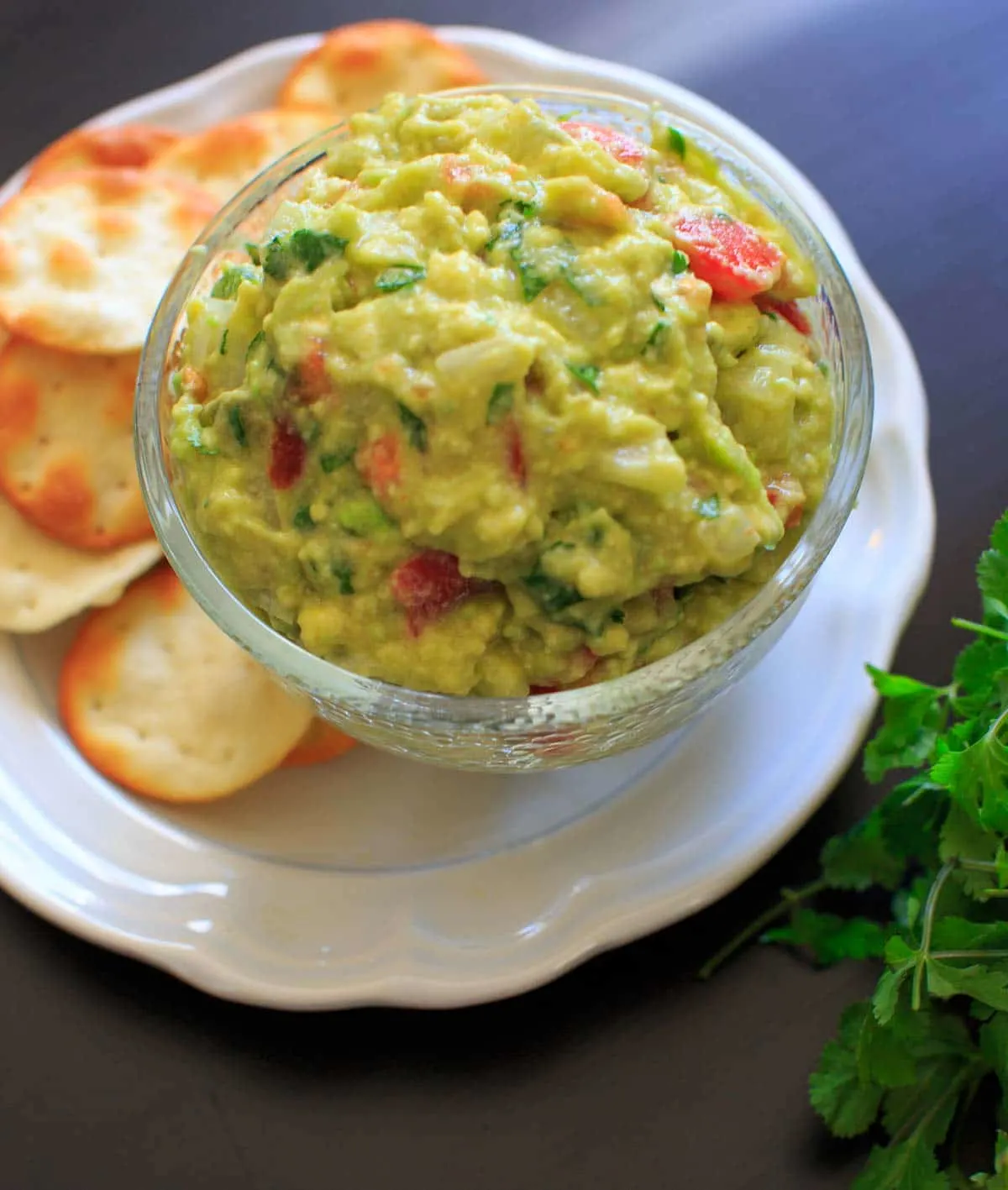 best ever guacamole in dish on top of white plate with crackers