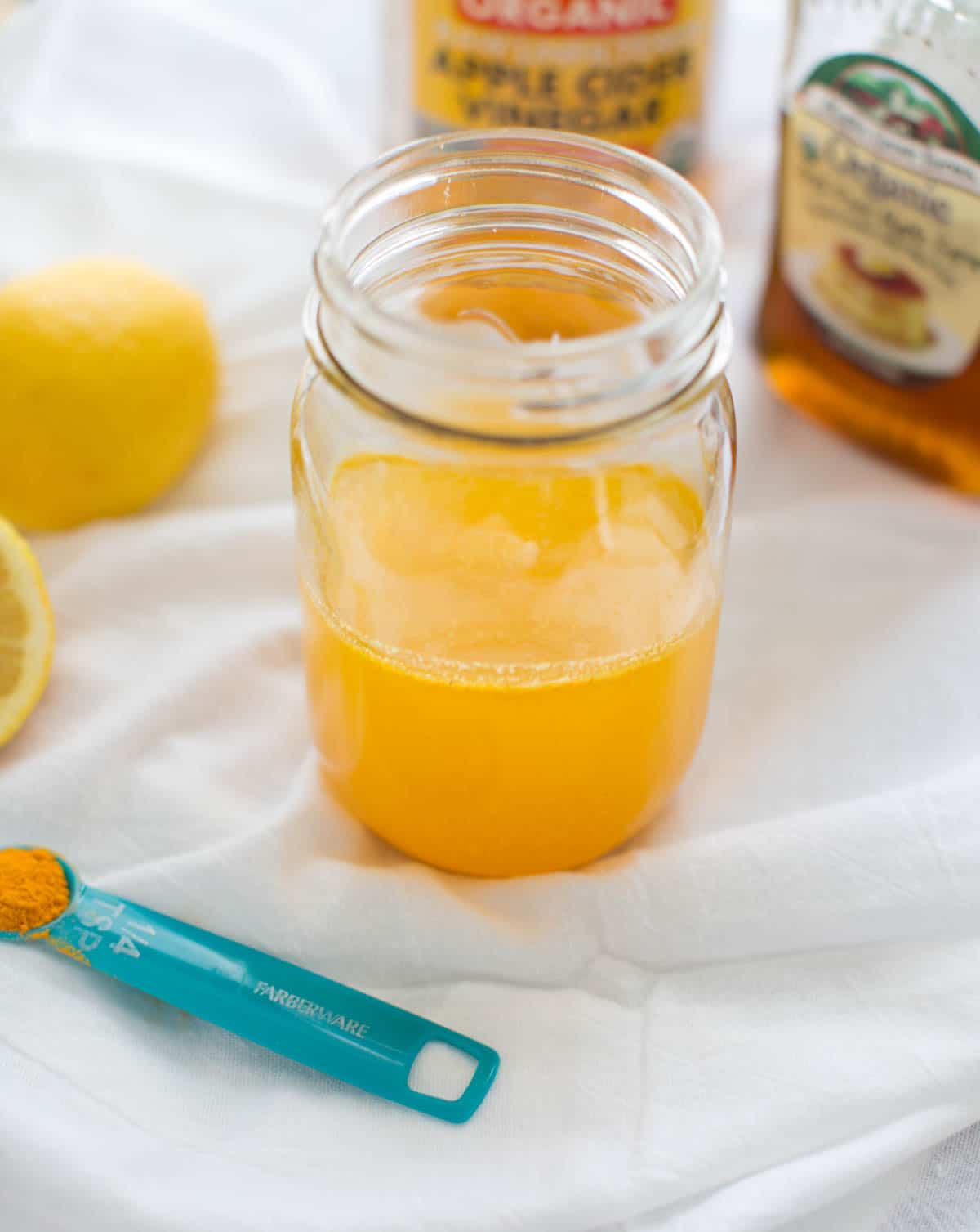 apple cider vinegar drink in clear mason jar with other ingredients surrounding