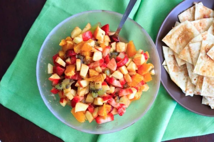 Fruit salsa made from apples, oranges, kiwis and strawberries and tortilla chips baked with cinnamon sugar. Colorful party appetizer or dessert!