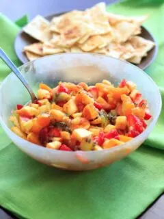 Fruit salsa made from apples, oranges, kiwis and strawberries and tortilla chips baked with cinnamon sugar. Colorful party appetizer or dessert!