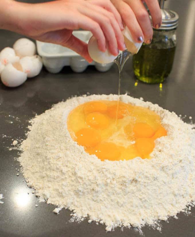 Dinner Party: How to make your own pasta from scratch. Eggs in flour.