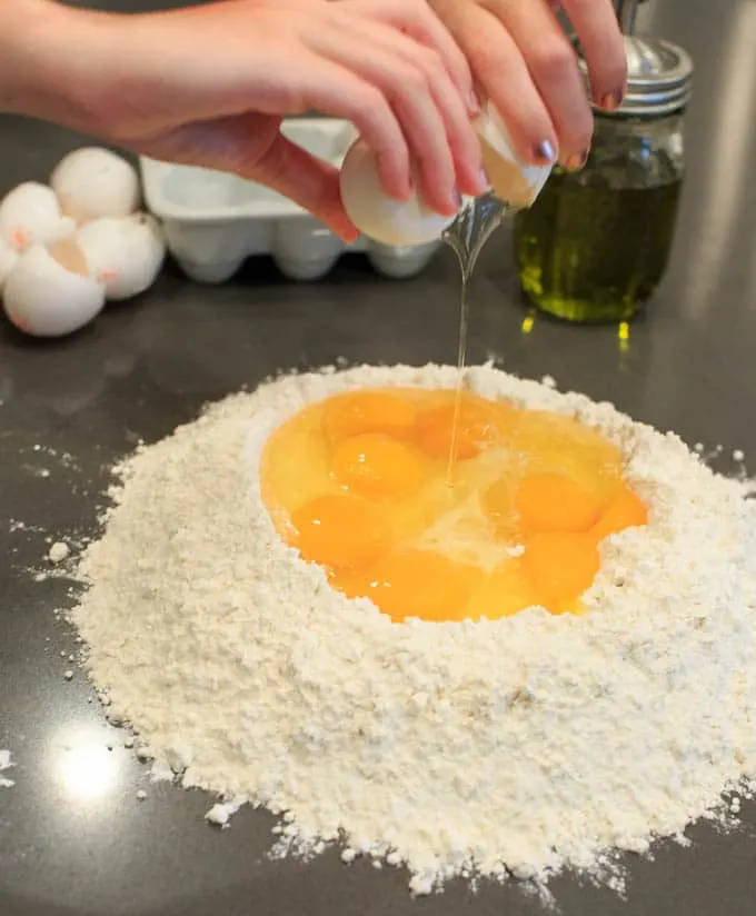 Dinner Party: How to make your own pasta from scratch. Eggs in flour.