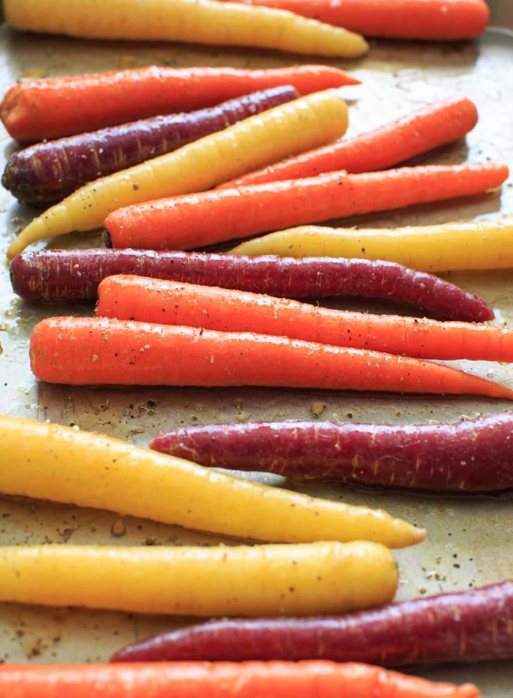 Maple roasted carrots are an easy vegetable side dish that you can throw together for any meal. Vegan and gluten-free, 5 ingredients or less. (Picture is before roasting, angle shot.)