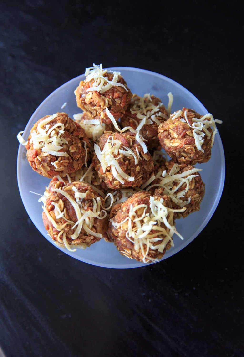 no-cake carrot cake bites in clear bowl on black table