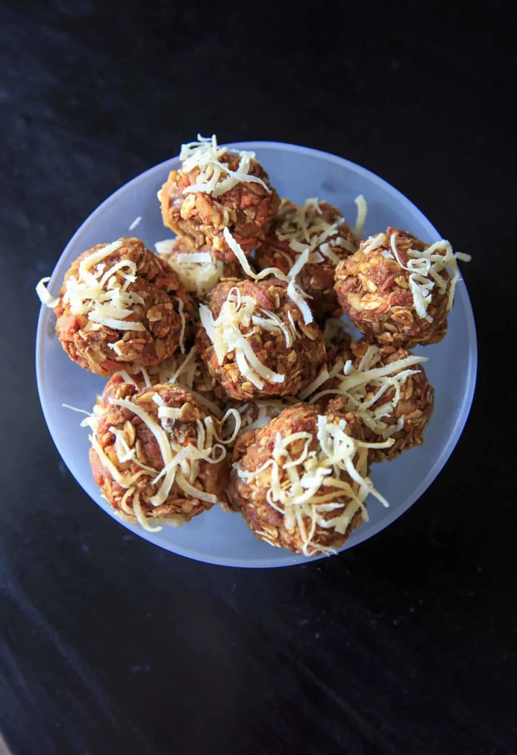 no-cake carrot cake bites in clear bowl on black table