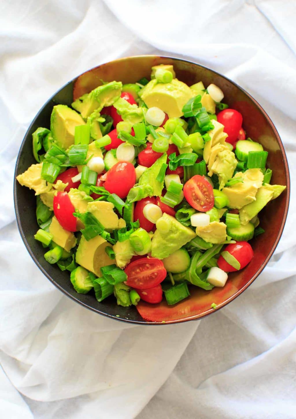 cucumber avocado farro salad in brown bowl before adding dressing