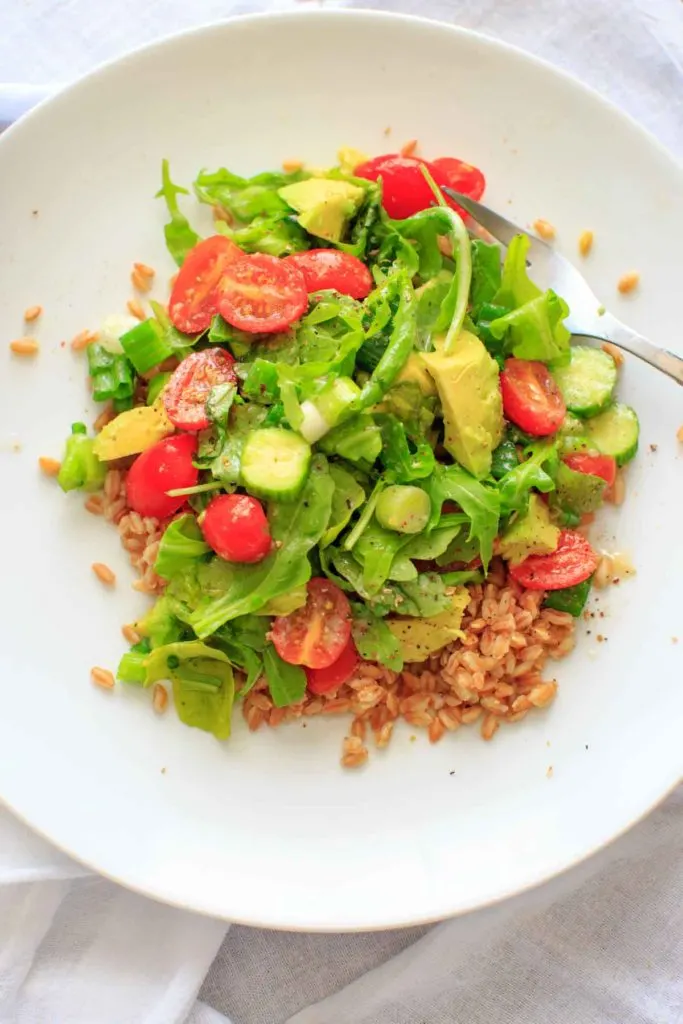 This cucumber avocado salad with miso vinaigrette is full of greens and veggies that can be eaten by itself (for gluten-free) or over a bed of farro for a heartier meal. Either way is a delicious vegan dish that is healthy and full of flavor!