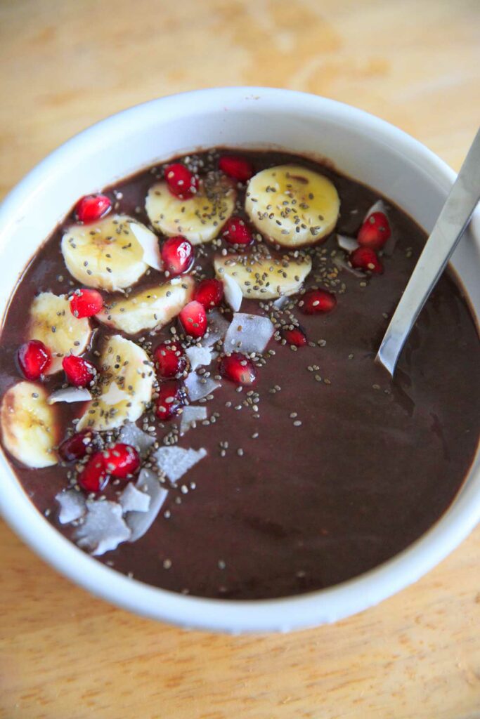 Pineapple Acai Smoothie Bowl or Boat. Bowl with banana, pomegranate arils, chia seeds and coconut.