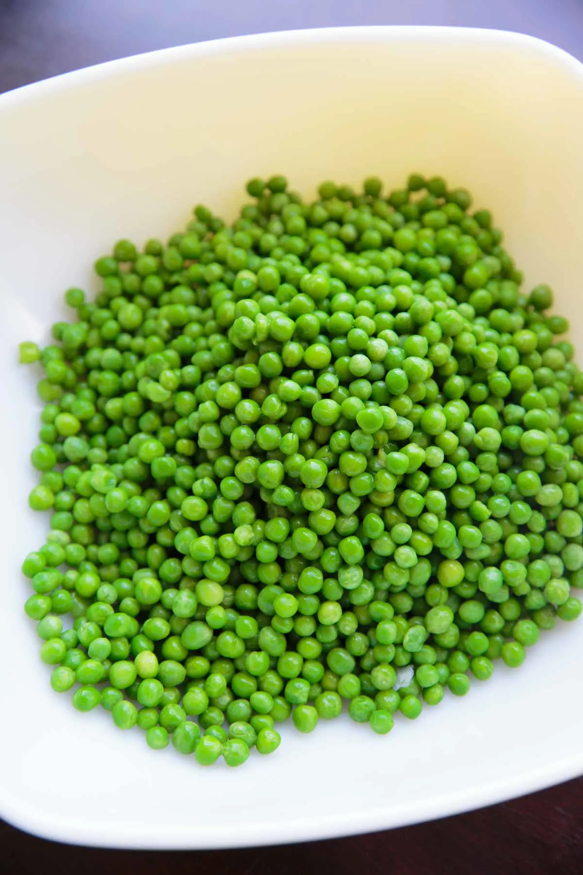 frozen peas rinsed in a bowl ready to make pea salad