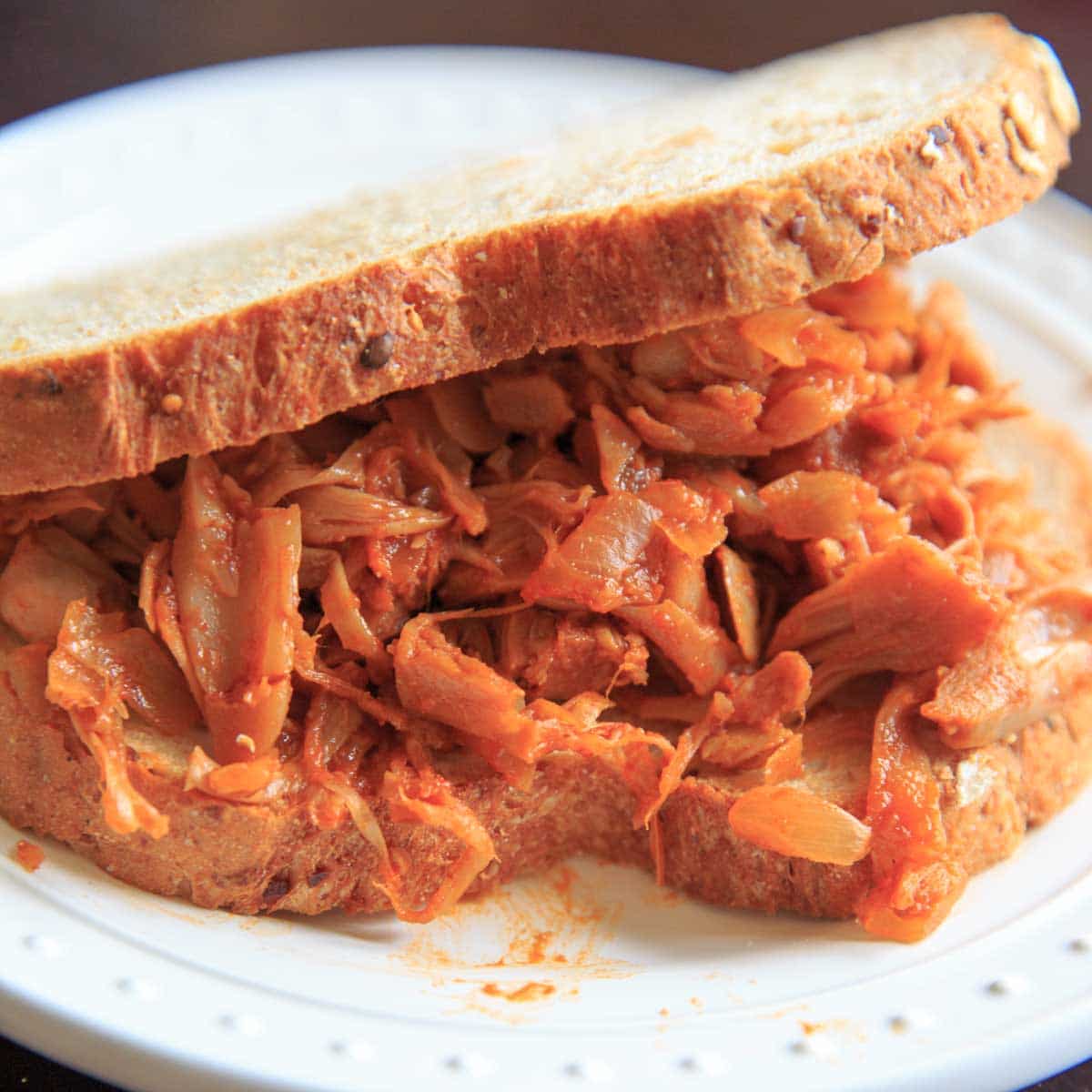 vegan bbq pulled jackfruit on sandwich on white plate