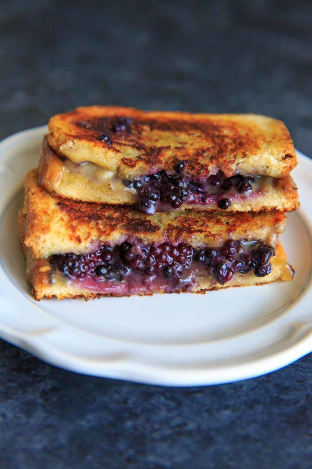 Blackberry Brie Grilled Cheese Sandwich cut in half on white plate