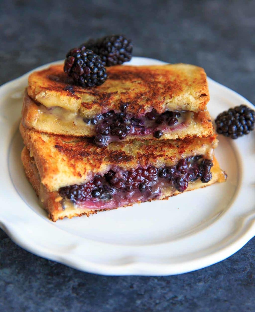 Blackberry Brie Grilled Cheese Sandwich cut in half on white plate