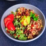 A customizable vegan and gluten-free buddha bowl with kale, quinoa, tomato, avocado, black beans, corn, and more!