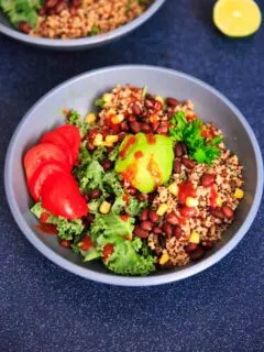 A customizable vegan and gluten-free buddha bowl with kale, quinoa, tomato, avocado, black beans, corn, and more!