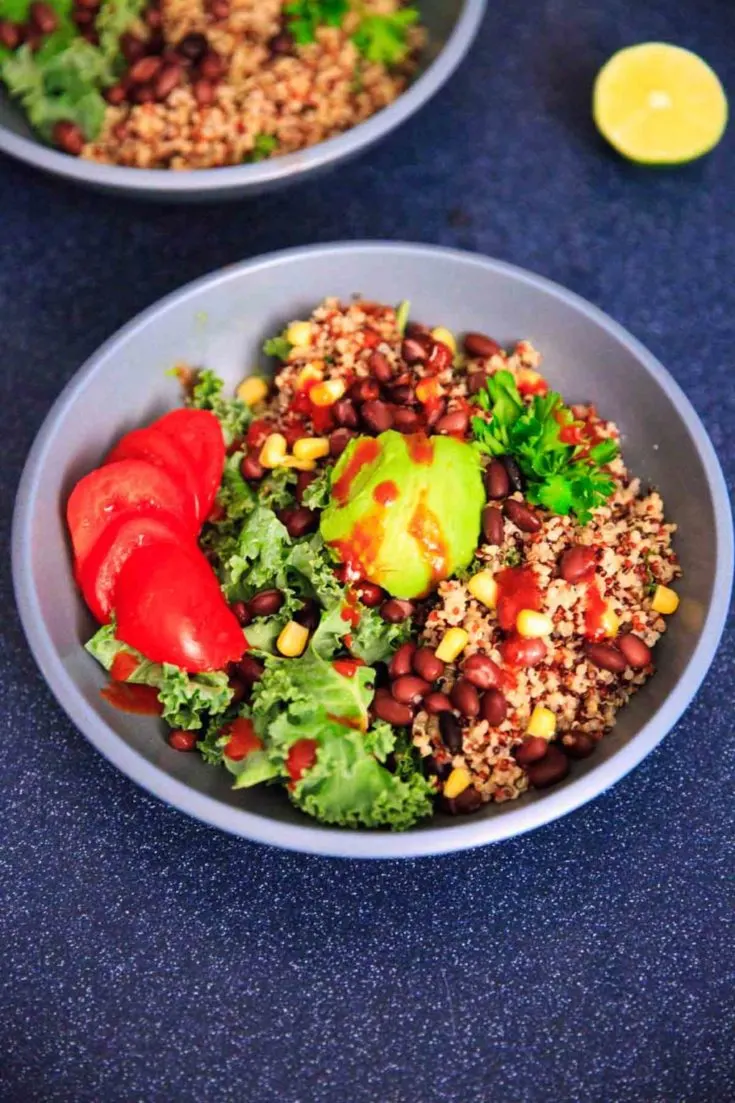 A customizable vegan and gluten-free buddha bowl with kale, quinoa, tomato, avocado, black beans, corn, and more!