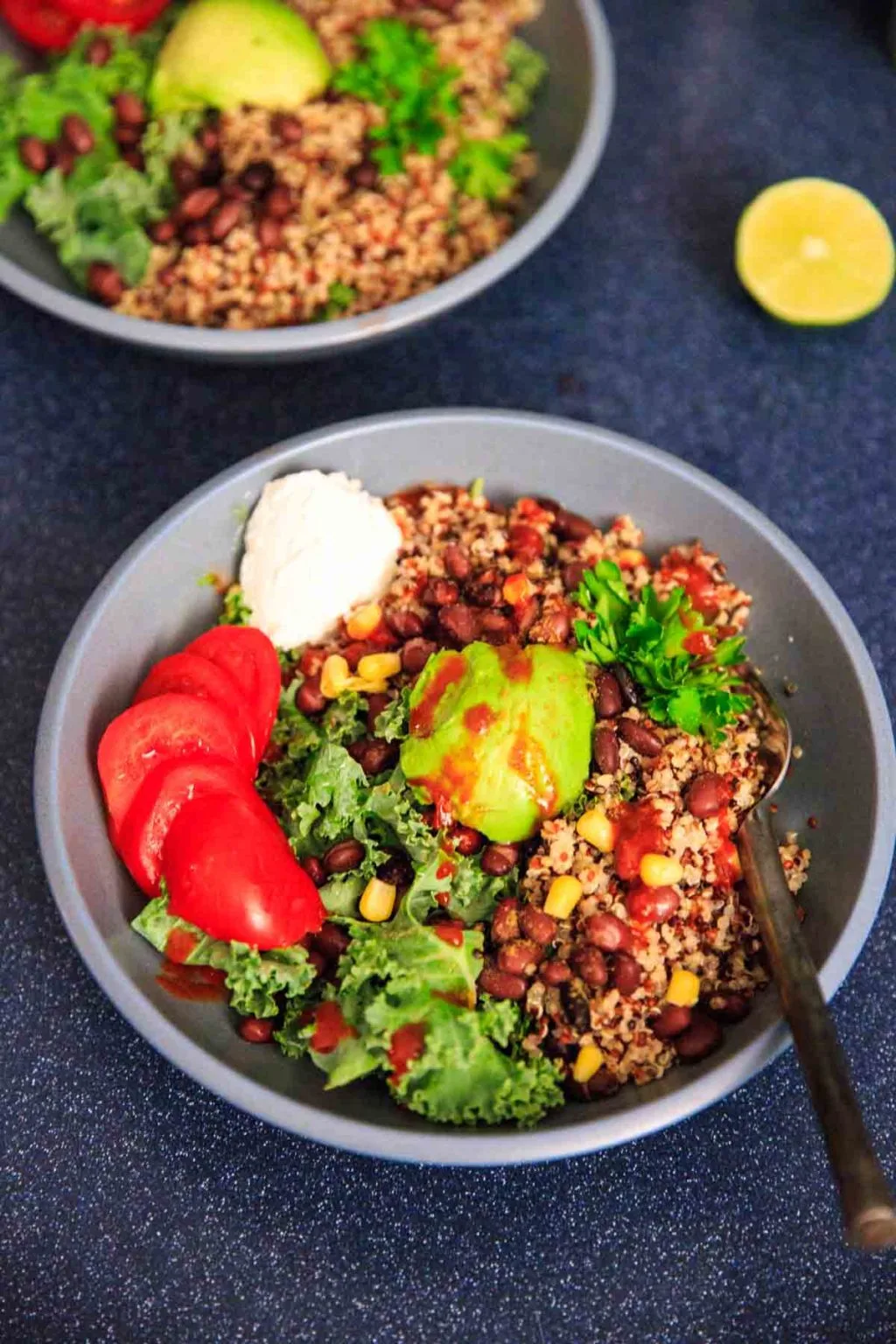 A customizable vegan and gluten-free buddha bowl with kale, quinoa, tomato, avocado, black beans, corn, and more!