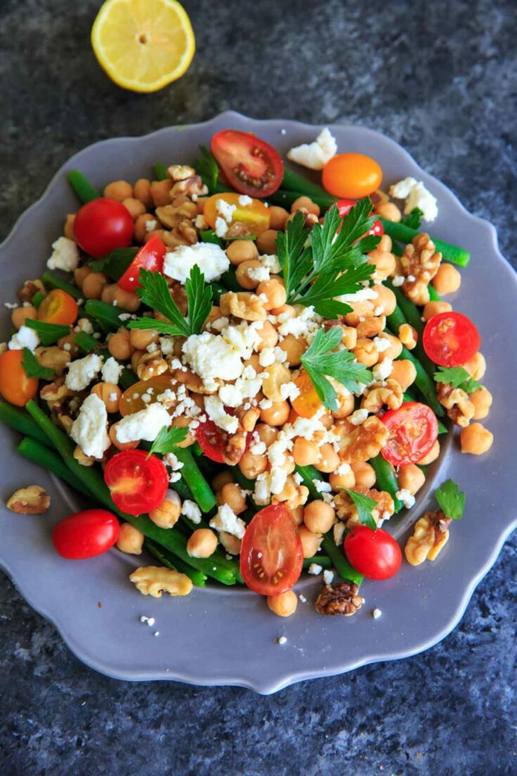 Green Bean Chickpea Salad with tomato, walnuts, feta cheese, parsley and lemon. A great appetizer or side dish for dinners or holiday gatherings!