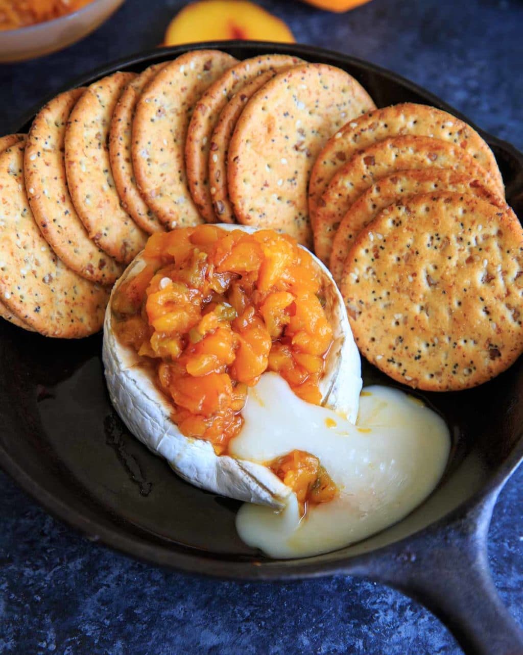 Peach Jalapeno Honey Baked Brie after cutting and cheese oozing out of side