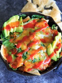 Oven-baked spinach nachos in a cast iron skillet. A great party snack, meal for 2 (or 1!) that has a little extra nutrition with greens.