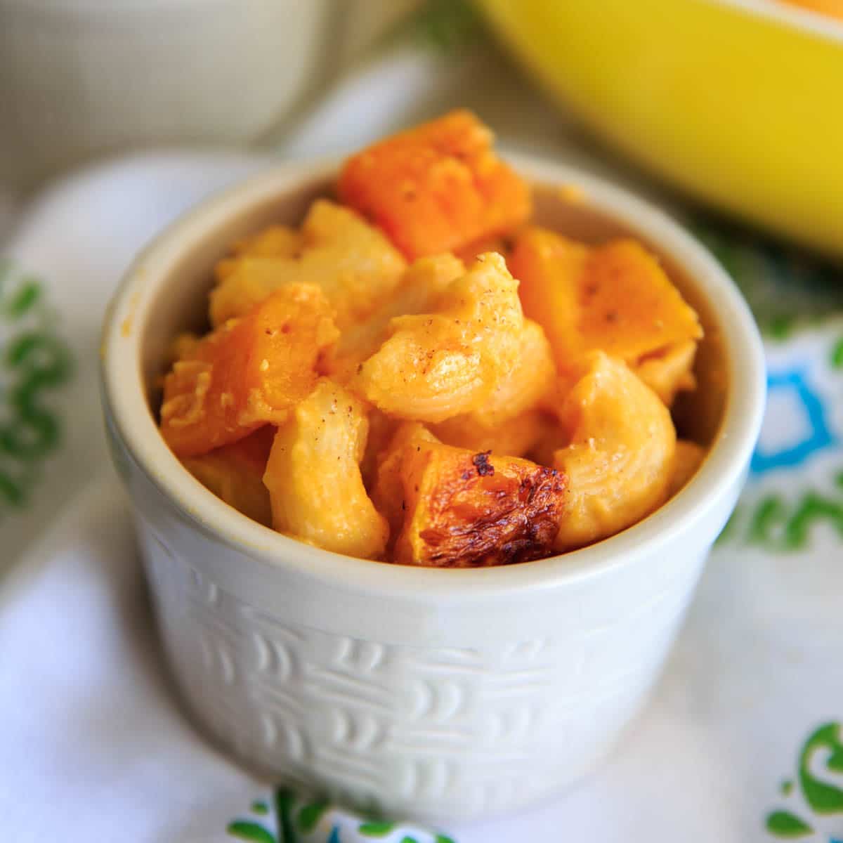 close up of small bowl of baked macaroni and cheese with butternut squash sauce