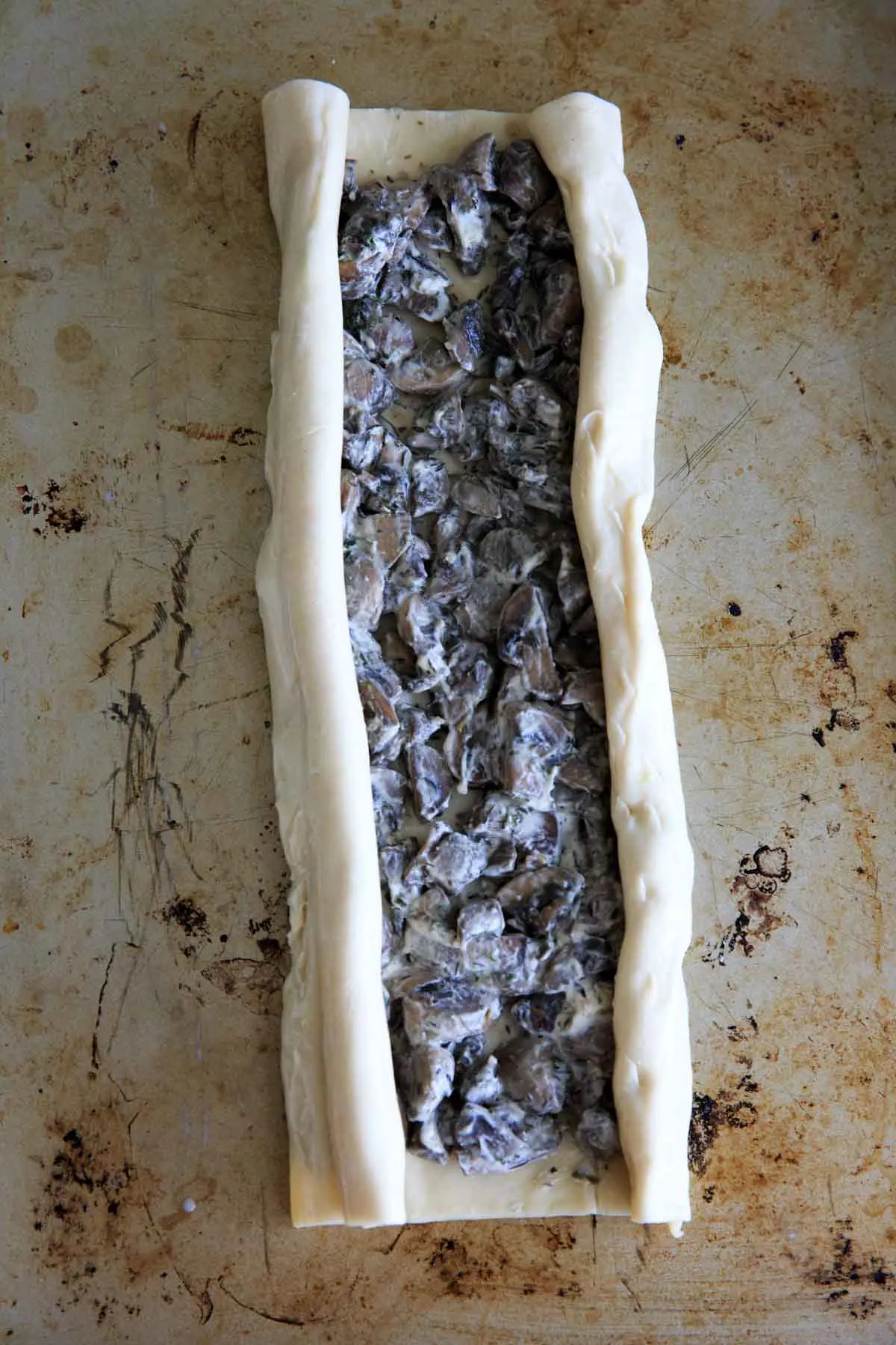 Making mushroom palmiers in puff pastry - rolling the puff pastry sides over into elephant ears