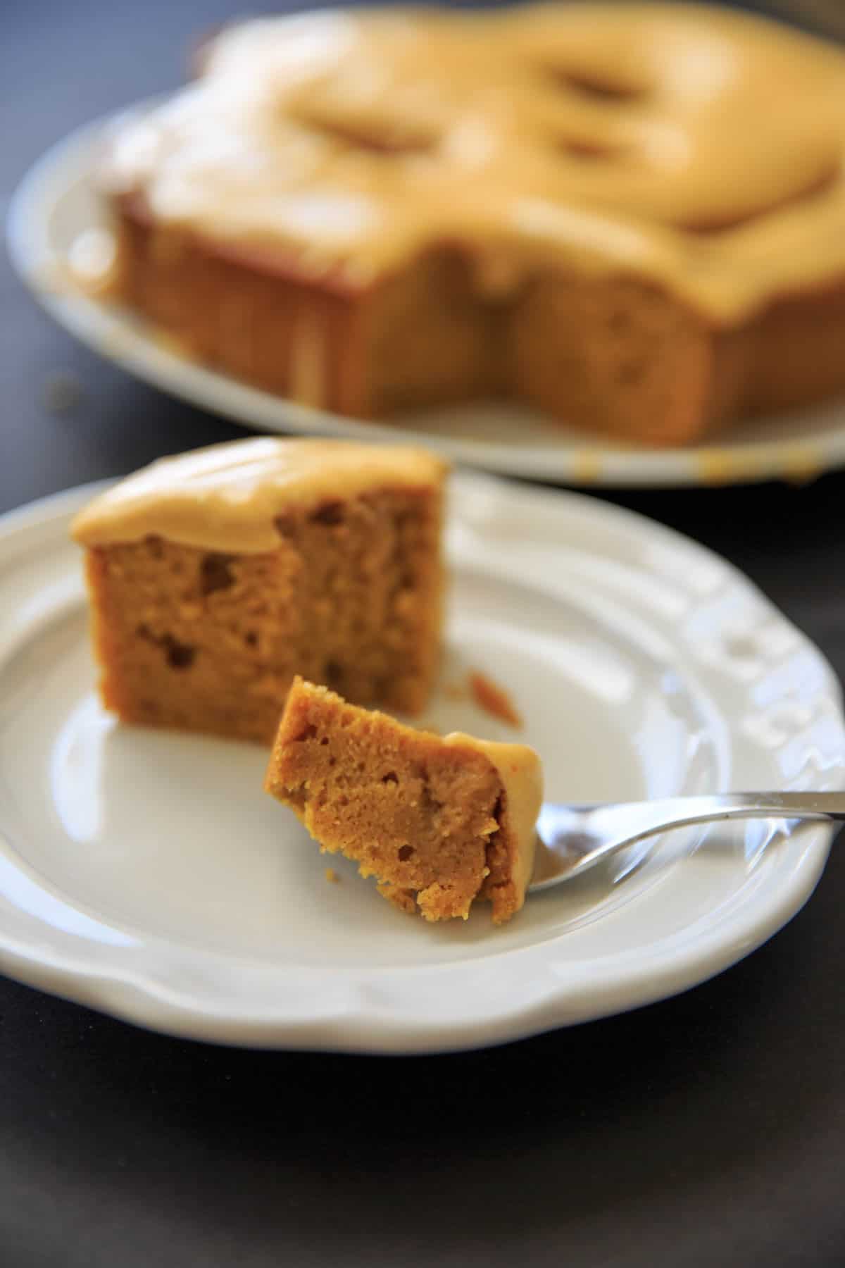Pumpkin Cake with Pumpkin Cream Cheese Icing. Piece of cake with bite on fork.
