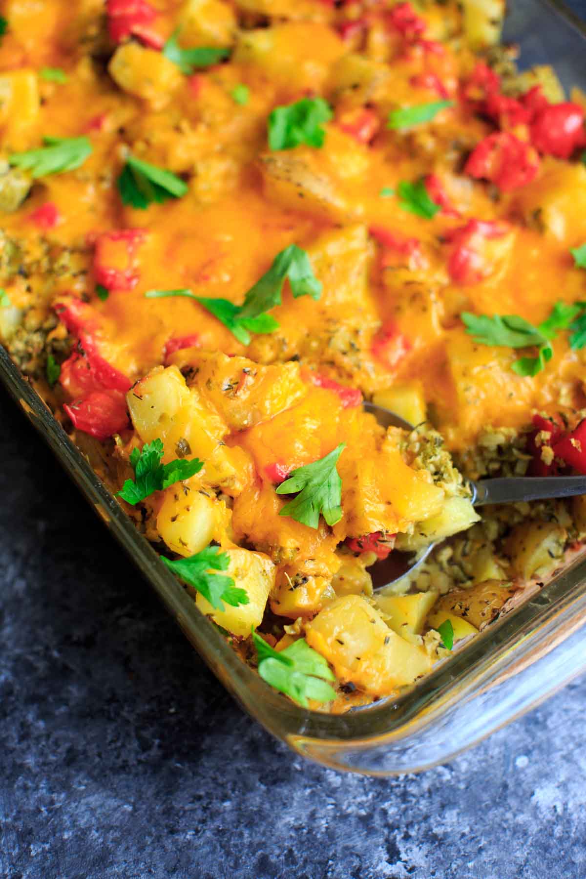 Broccoli and cheese baked potato casserole with parsley, with spoon scoop