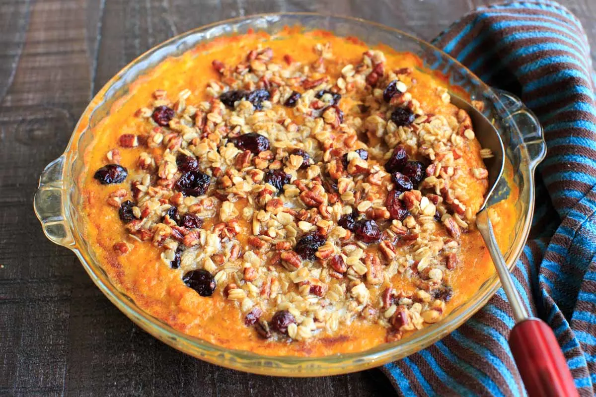 Sweet potato casserole with an oat, pecan and cranberries topping and sweetened with maple syrup. No sugar added!