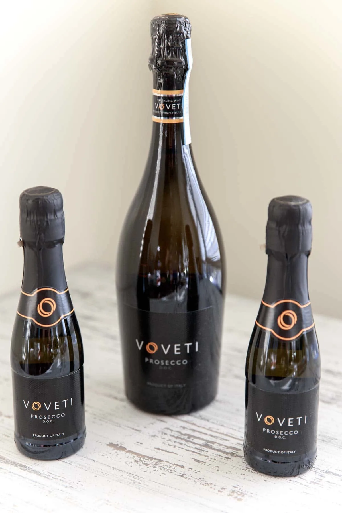 bottle of  Voveti Prosecco next to 2 mini bottles
