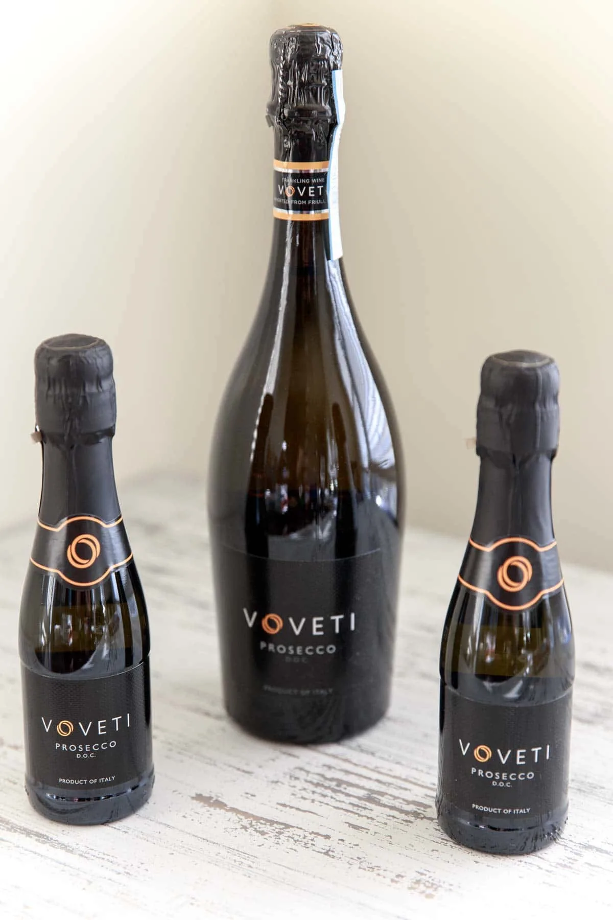 bottle of Voveti Prosecco next to 2 mini bottles