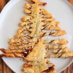 A Christmas-tree shaped dessert made with puff pastry, Nutella and peanut butter. Perfect for sharing at parties, super easy to make and only 3 ingredients. Top with powdered sugar or decorative sprinkles.