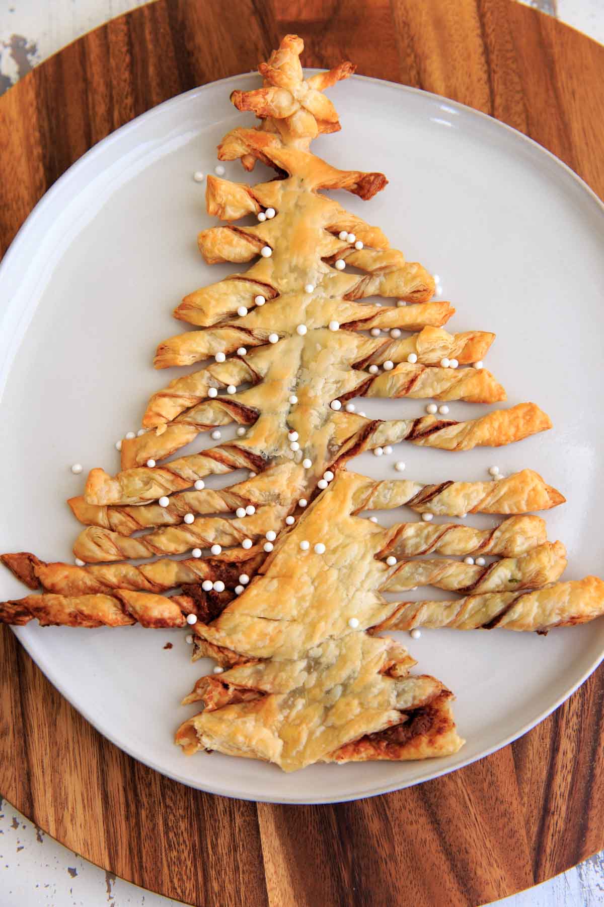 A Christmas-tree shaped puff pastry dessert on white plate