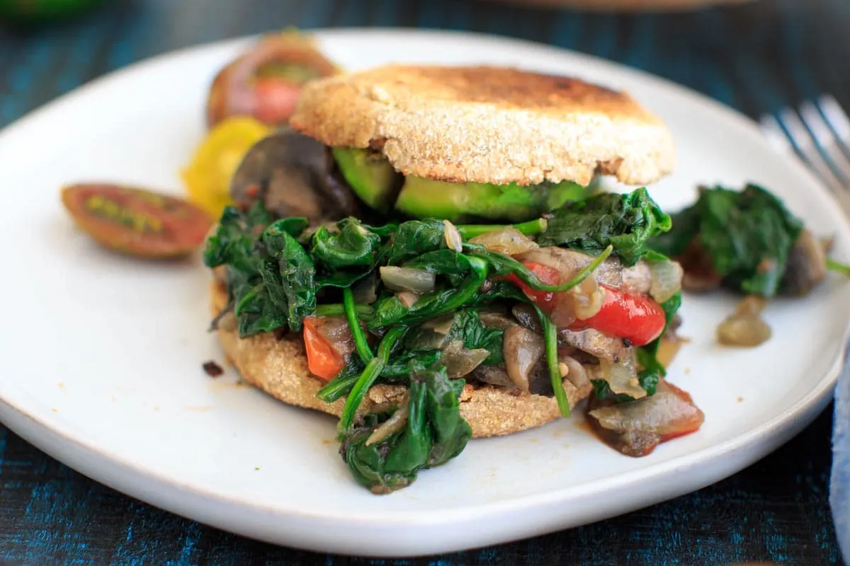 Ultimate Vegan Breakfast Sandwich with cooked veggies on white plate