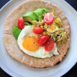 A quick breakfast idea: avocado, tomato, and egg on a pita wrap.