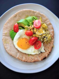 A quick breakfast idea: avocado, tomato, and egg on a pita wrap.