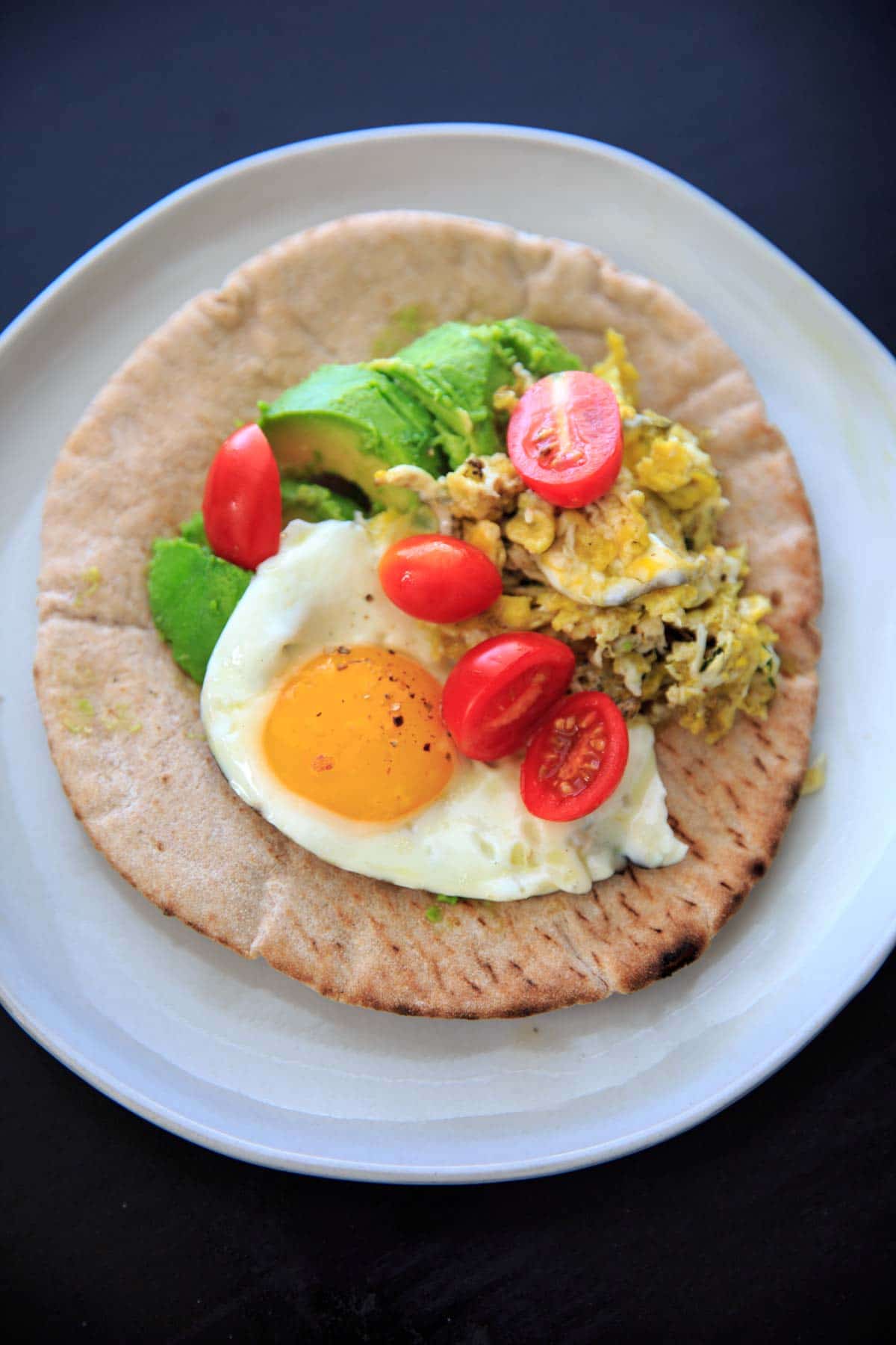 A quick breakfast idea: avocado, tomato, and egg on a pita wrap.