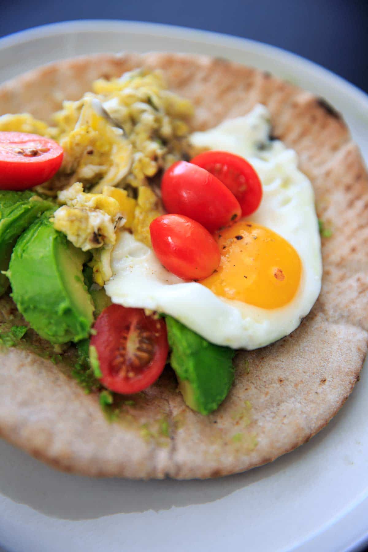 A quick breakfast idea: avocado, tomato, and egg on a pita wrap.