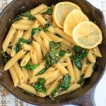 Lemon Spinach Pasta with lemon slices in a cast iron pan