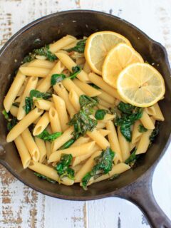 Lemon Spinach Pasta with lemon slices in a cast iron pan