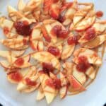 This peanut butter jelly combo on apple nachos is the perfect quick and healthy snack for kids and adults alike! Vegan, gluten-free, protein-packed and delicious.