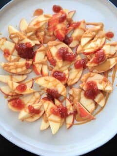 This peanut butter jelly combo on apple nachos is the perfect quick and healthy snack for kids and adults alike! Vegan, gluten-free, protein-packed and delicious.