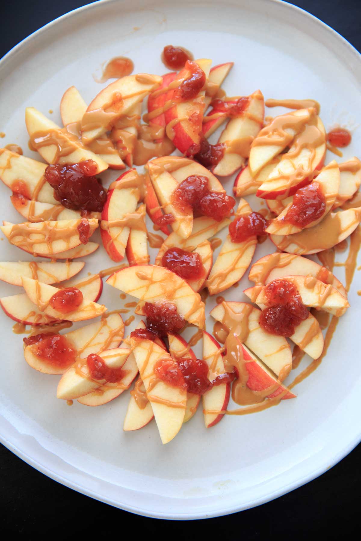 This peanut butter jelly combo on apple nachos is the perfect quick and healthy snack for kids and adults alike! Vegan, gluten-free, protein-packed and delicious.
