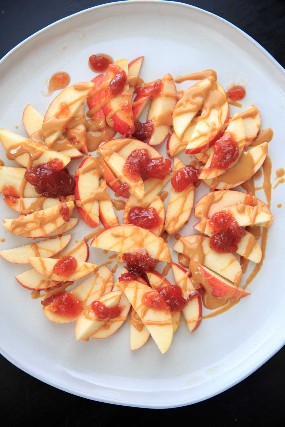 This peanut butter jelly combo on apple nachos is the perfect quick and healthy snack for kids and adults alike! Vegan, gluten-free, protein-packed and delicious.