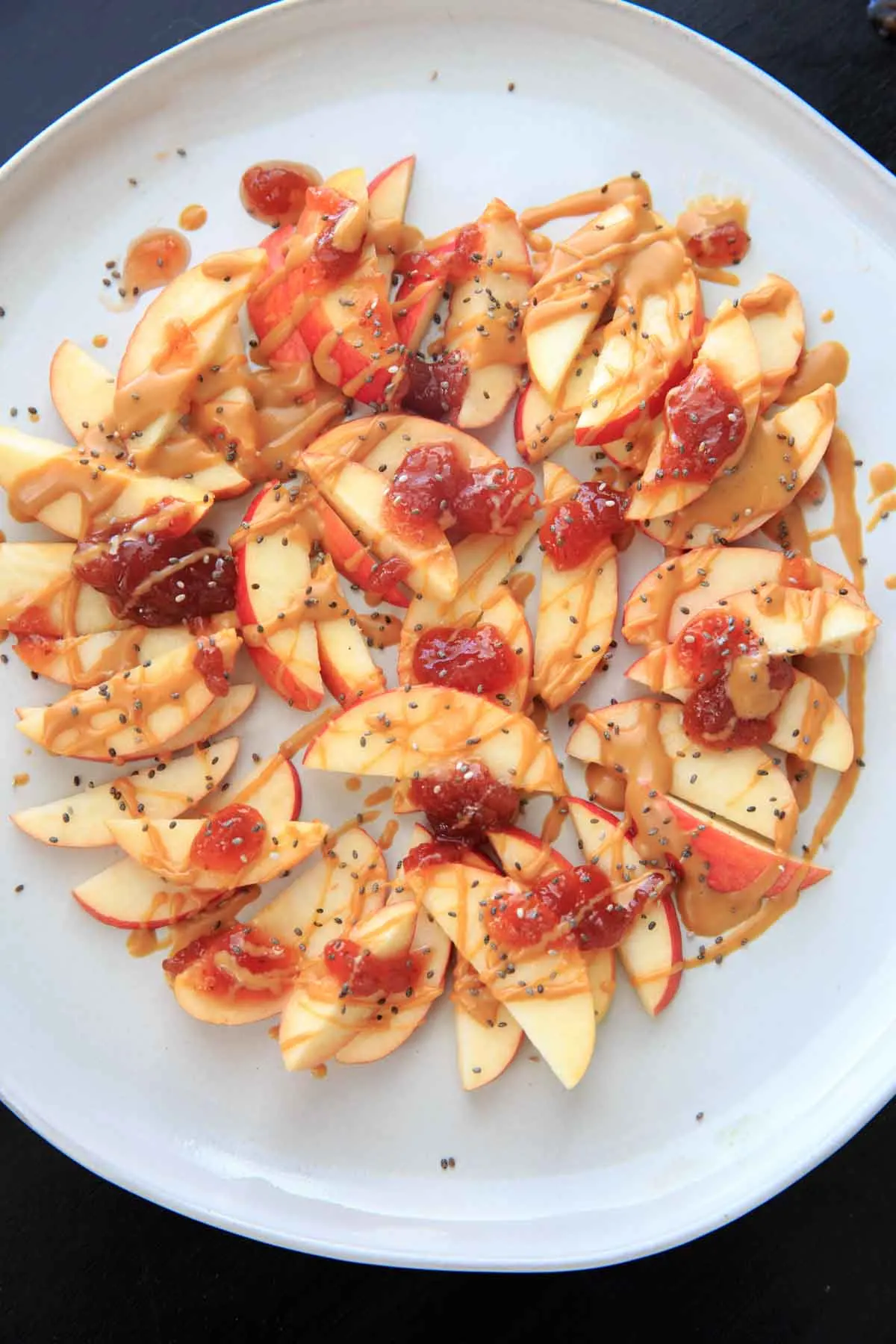 This peanut butter jelly apple nachos recipe is the perfect quick and healthy snack for kids and adults alike! Vegan, gluten-free, protein-packed and delicious.