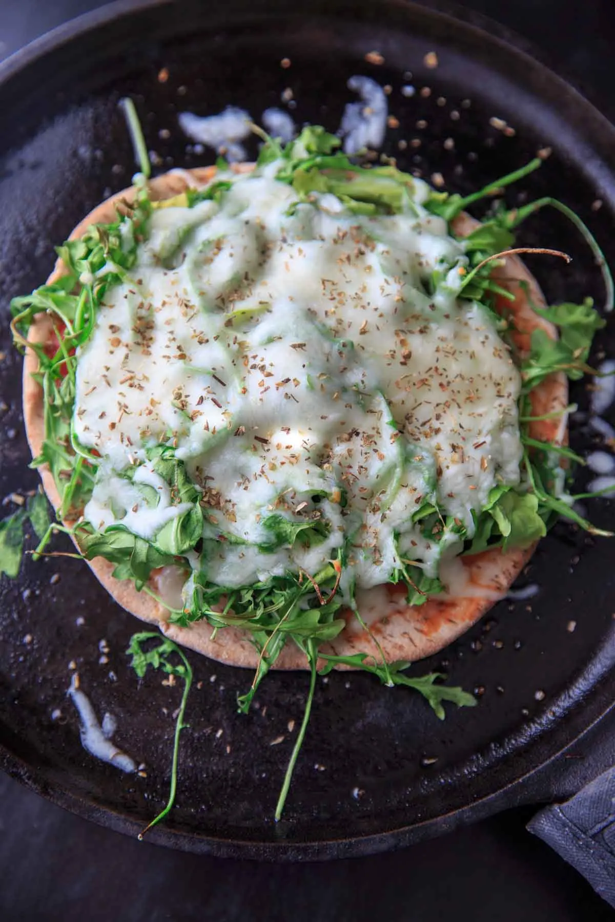 Quick and easy pita pizza recipe that you can make in the oven, microwave, or even on the grill! Fast lunch or dinner option that is completely customizable and faster than delivery.