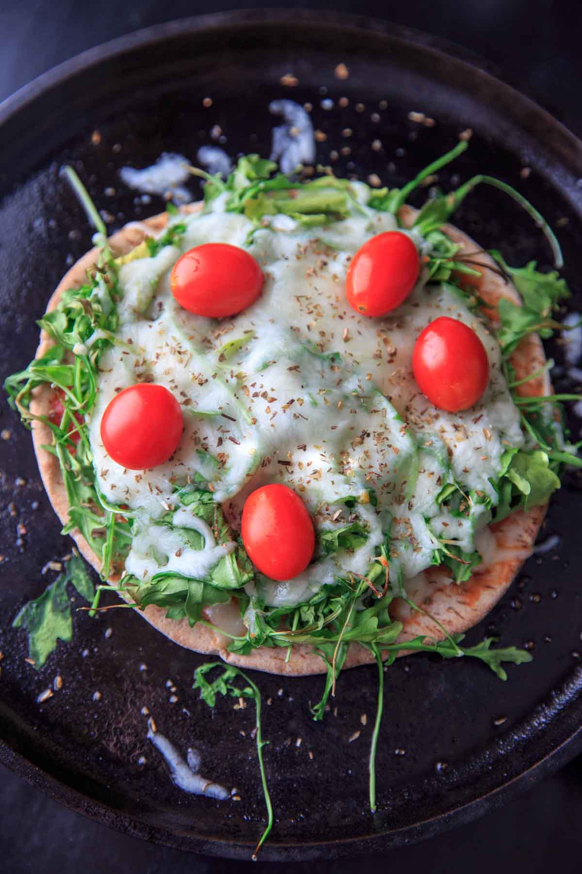 Quick and easy pita pizza recipe that you can make in the oven, microwave, or even on the grill! Fast lunch or dinner option that is completely customizable and faster than delivery.