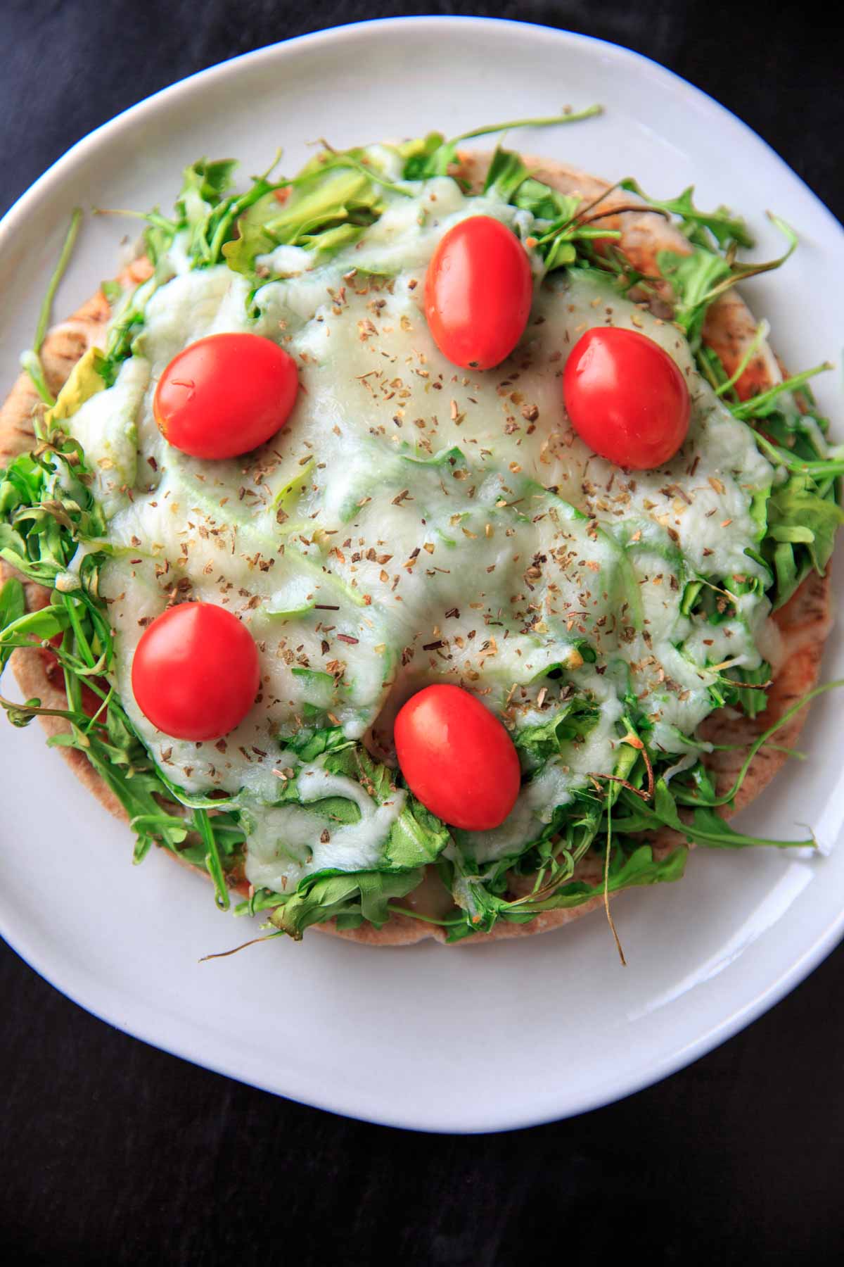 Quick and easy pita pizza recipe that you can make in the oven, microwave, or even on the grill! Fast lunch or dinner option that is completely customizable and faster than delivery.