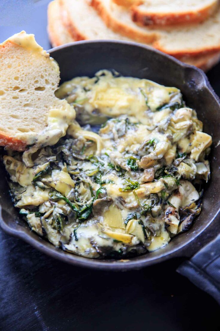 Arugula (or spinach) and artichoke brie dip, made in a cast iron skillet. A delicious and unique appetizer!