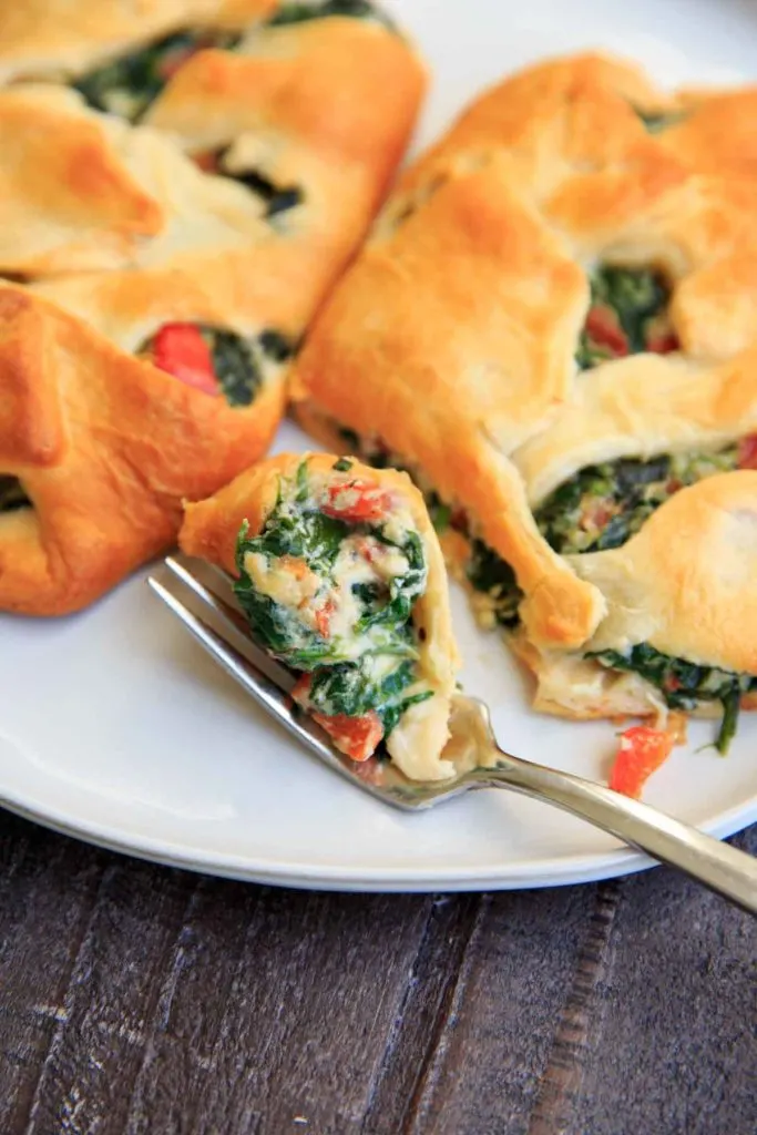 Spinach Ricotta Crescent Wrap cut in half with a bite on fork